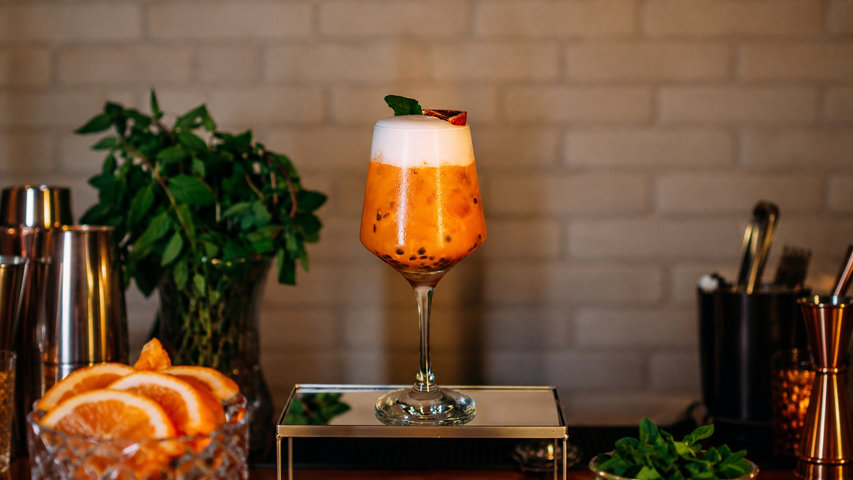 Taça de maracujá com espuma e hortelã no centro do bar